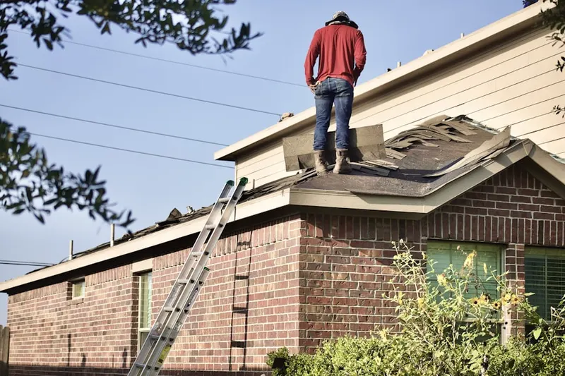 Professional roofer working on a residential roof in Powder Valley